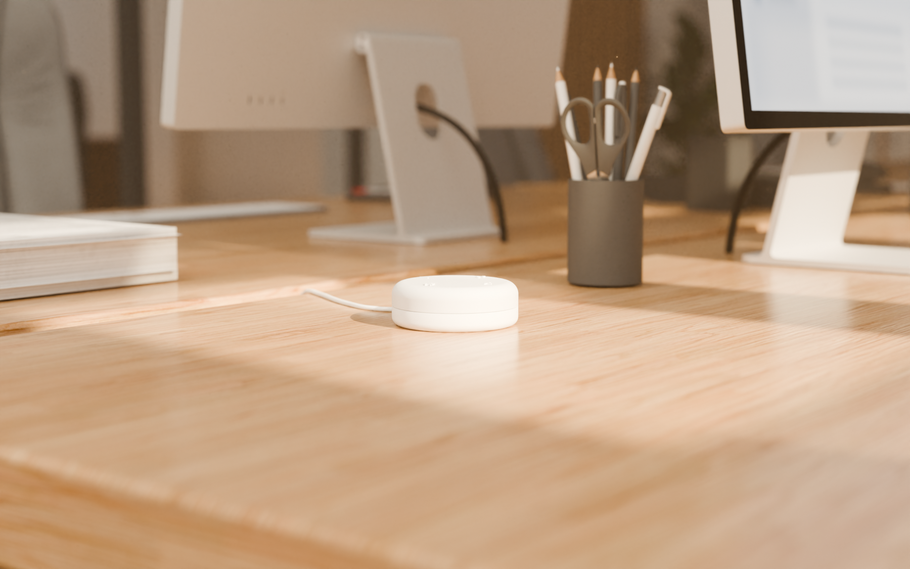 Lighthouse’s white recorder on a wooden desk with monitors and office supplies in soft focus behind it